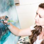 A photograph of Donna Giraud in her studio painting.