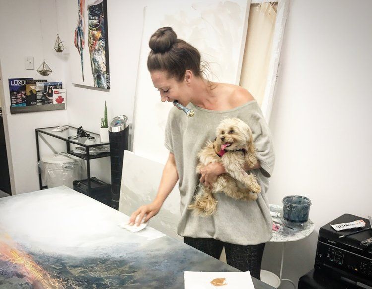 A photo of Donna Giraud painting with Wallis her dog.