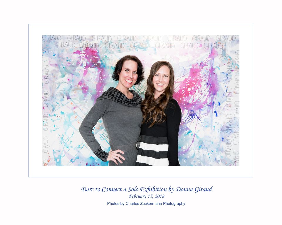 A photo of Shannon Little and Donna Giraud standing in front of one of Donna's paintings. Shot taken at Dare to Connect a Solo Exhibition.